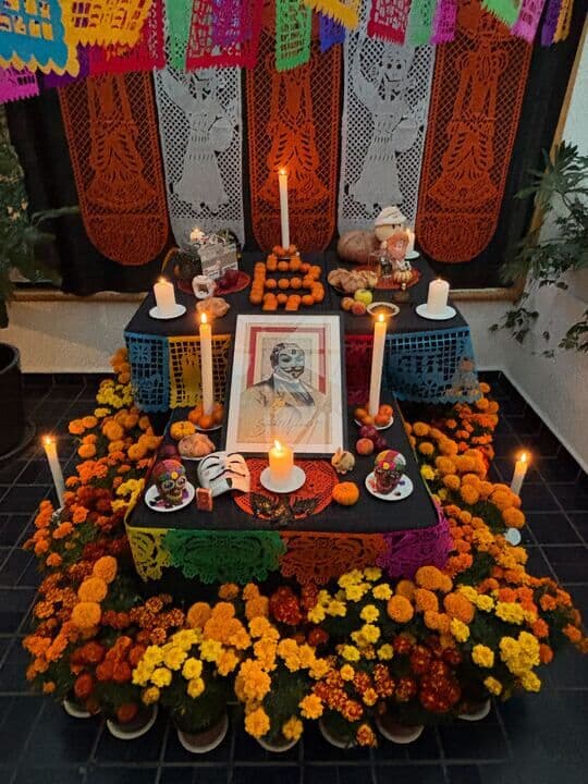 El altar de Día de Muertos de la casa, cempasúchil y velas