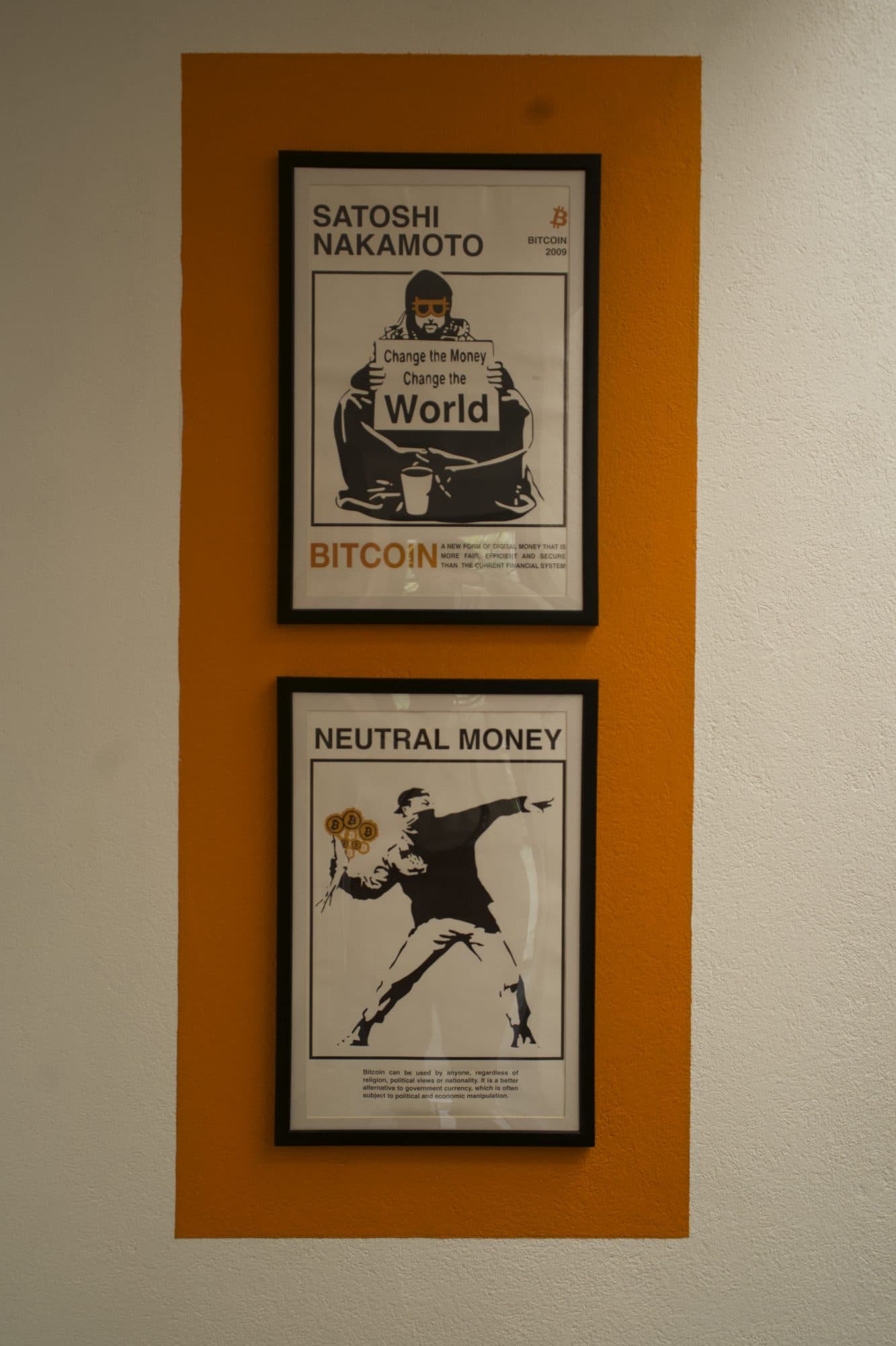 Dos pósters de Bitcoin sobre una franja naranja: Satoshi Nakamoto y Neutral money