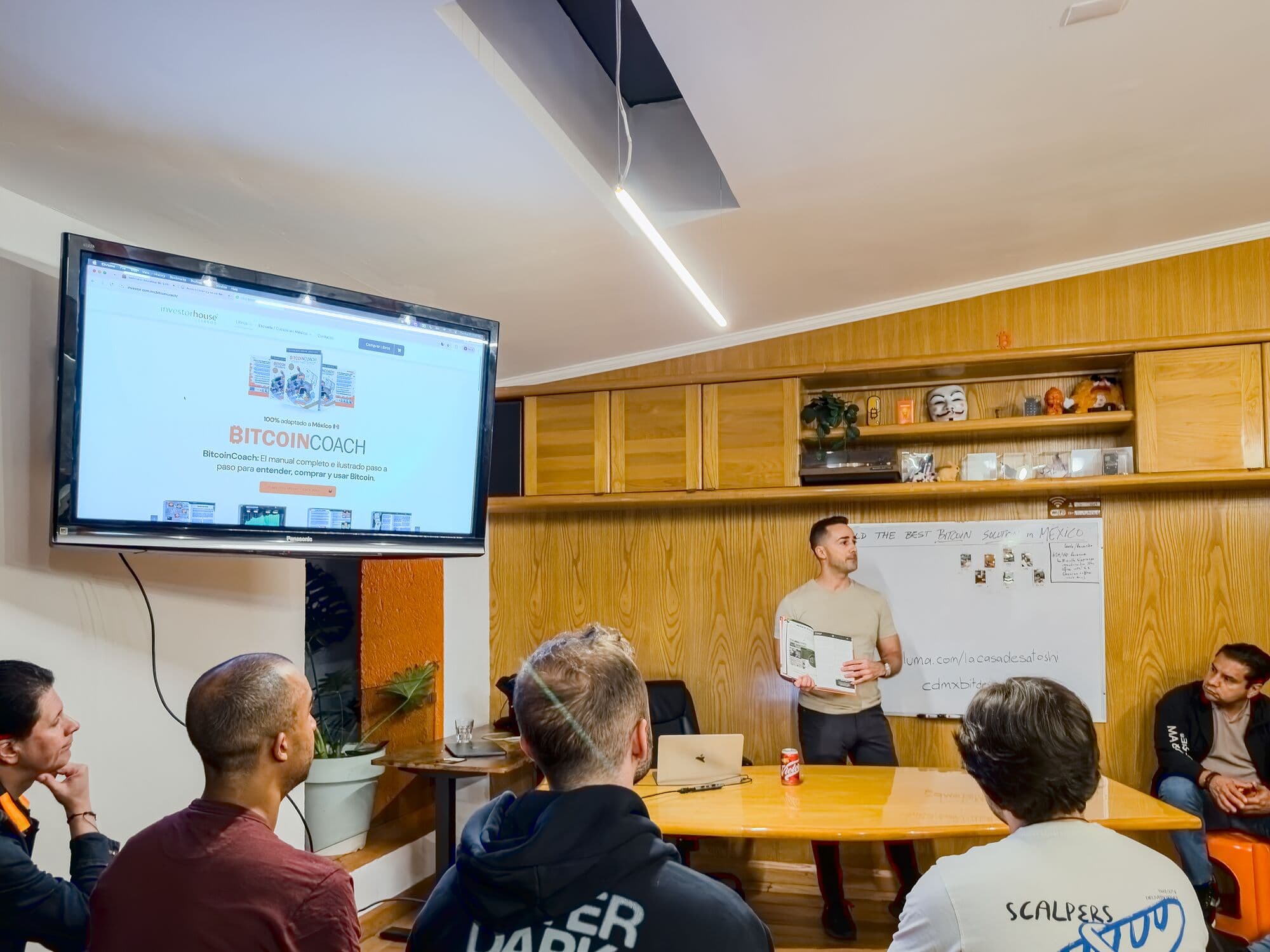 La sala de juntas: mesa larga, pantalla y pizarrón