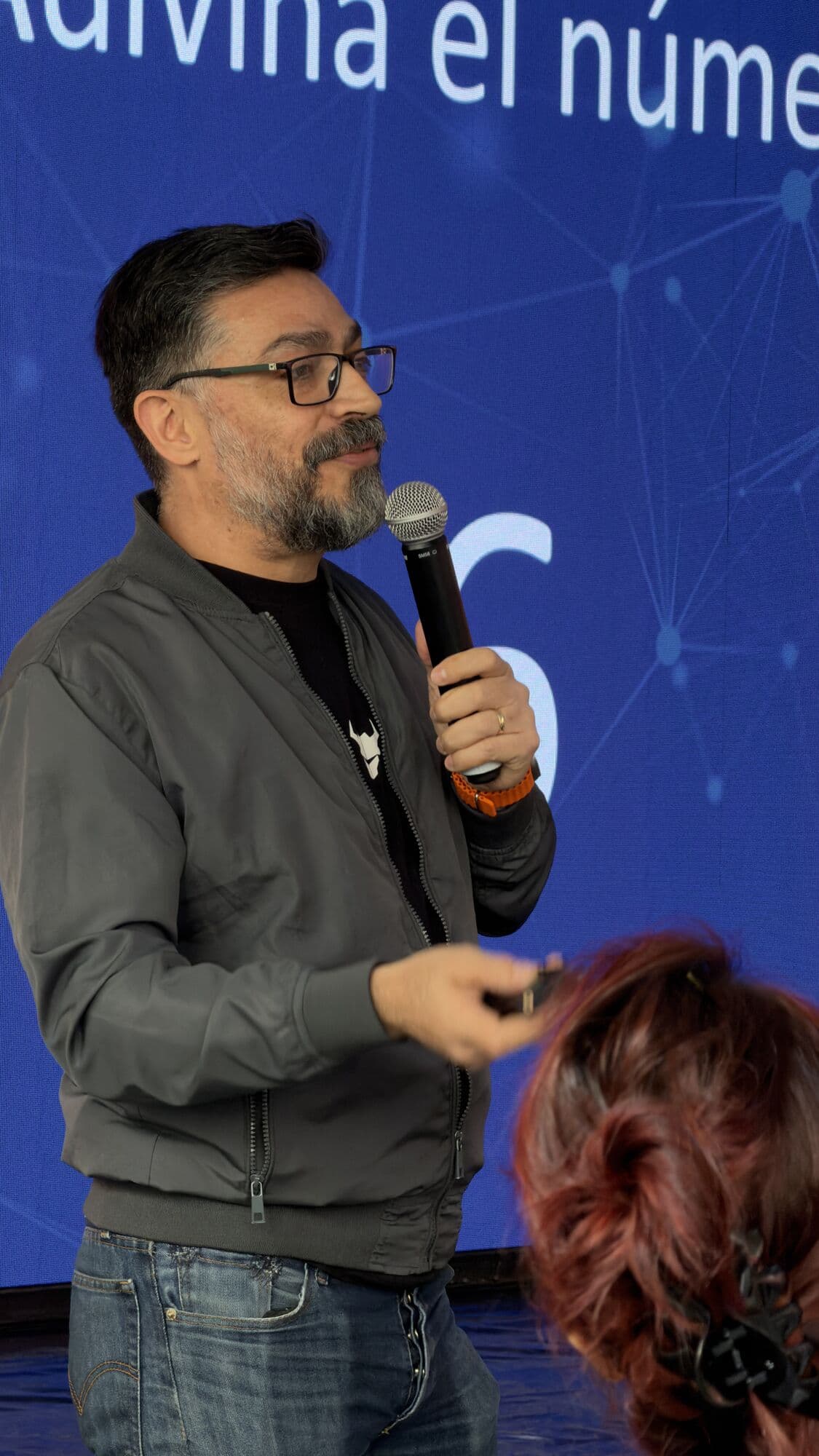 Un ponente con micrófono a media charla